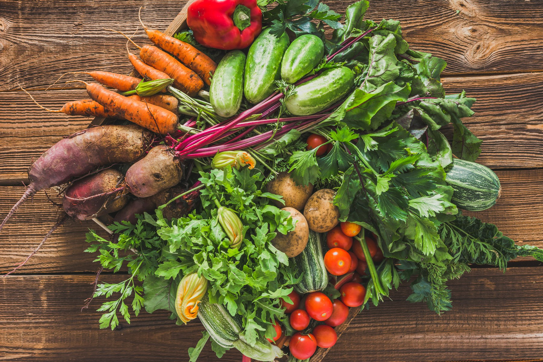 Fresh organic vegetables harvest. Local farmer market with vegetable box on wooden background, vegetarian food concept